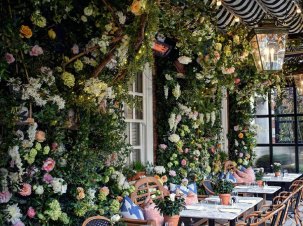 Cafe dengan teras yang dikelilingi oleh pohon-pohon bunga